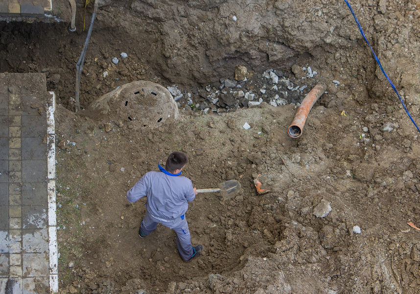 Repair of clogged septic and sewer piping sewer line replacement. Excavating the sewer line. View from above.