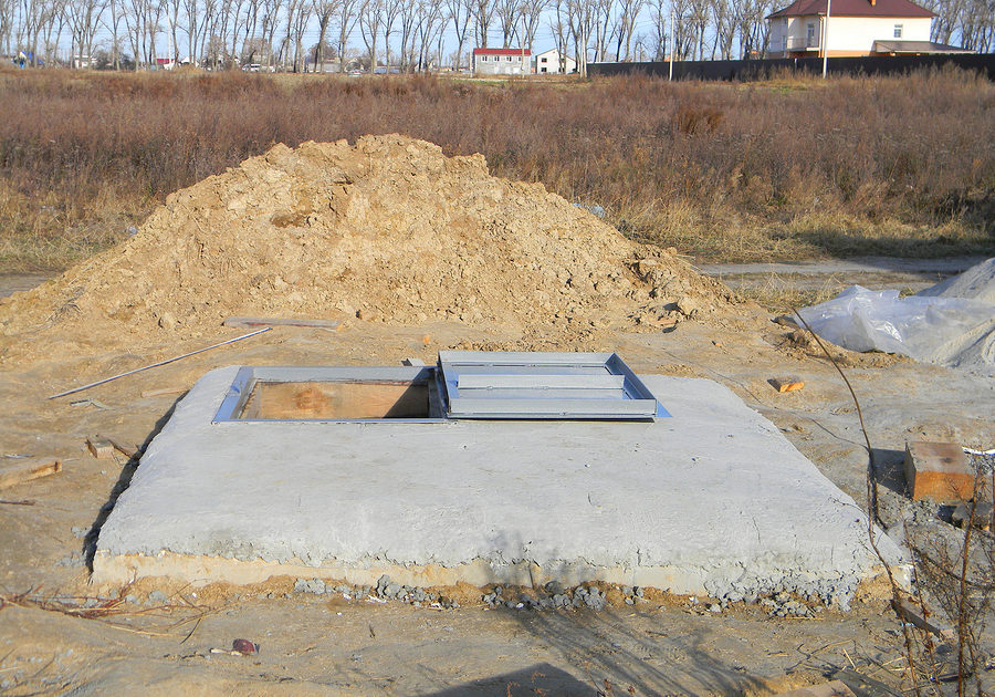 Manhole cover installation with sewer tank outdoors.